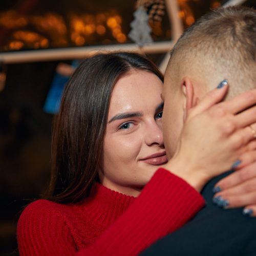 Young couple in love hug each other on the black background